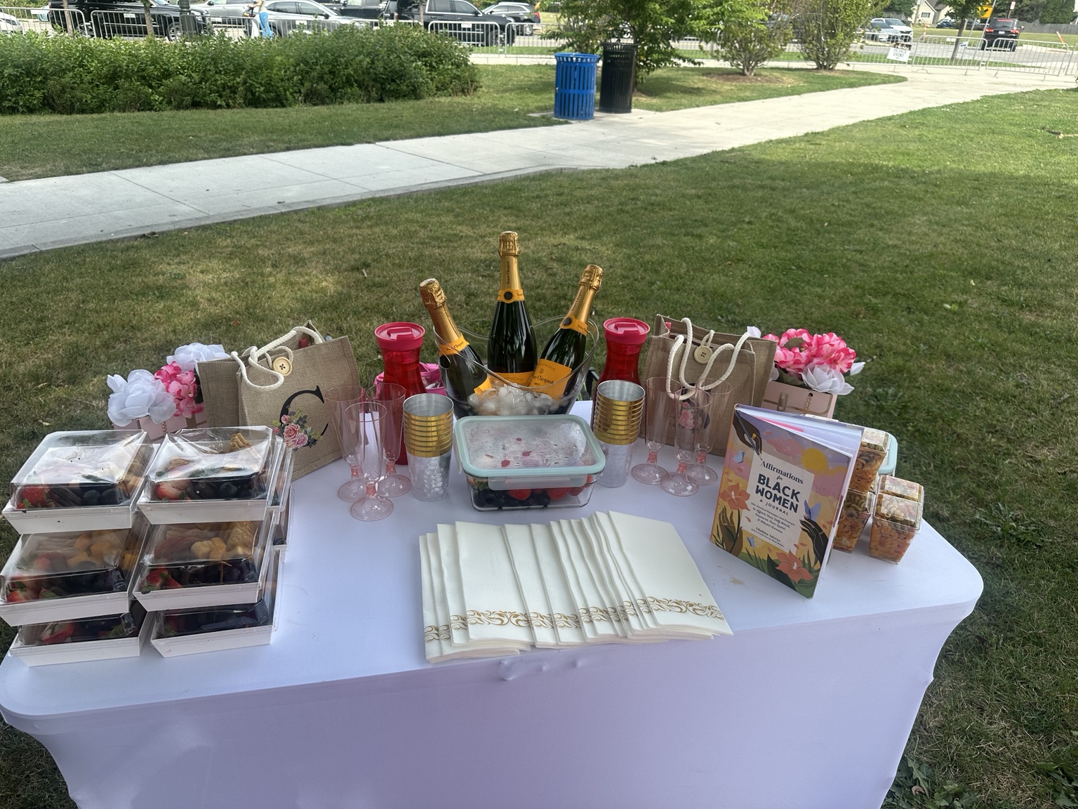 A picnic table set with treats, flowers, keepsakes, and refreshments